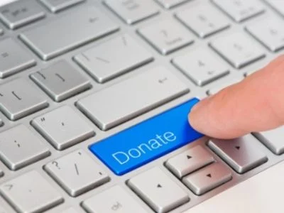 person pressing donate button on a keyboard