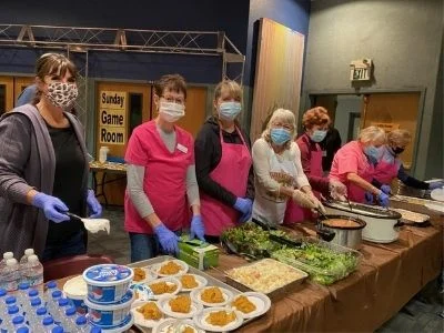 group of women serving a meal to the Pathfinders group
